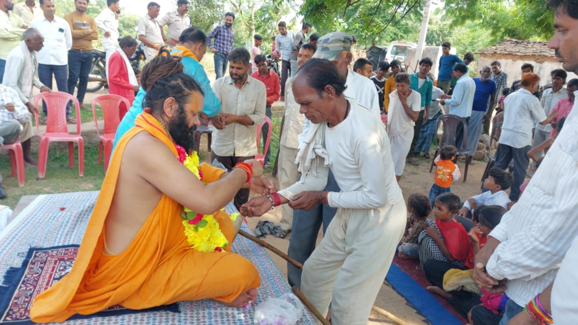 लोगों को रक्षा सूत्र बांधते पुरूषोत्तमदास महाराज