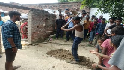 मेजा में हत्या के आरोपियों के घर के सामने शव दफन करने के लिए कब्र खोदते ग्रामीण।