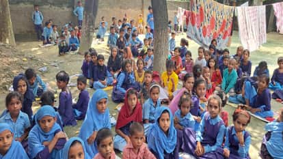 खुले आसमान में पेड़ के नीचे बैठ कर पढ़ाई करते बच्चे