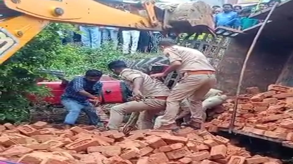 Tractor-trolley full of bricks overturned