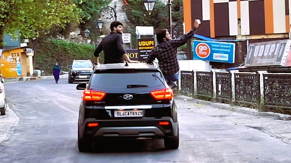 Delhi youth stunts on Mussoorie Mall Road took selfie sitting on roof of car and hanging on gate