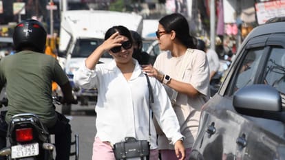 धूप व गर्मी से बचने के लिए चश्मा लगाकर जाती युवतियां।
