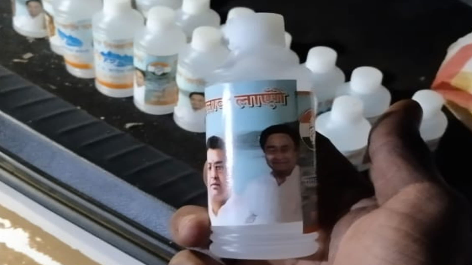 कमलनाथ और कांग्रेस प्रत्याशी की फोटो लगी गंगाजल की बोतल