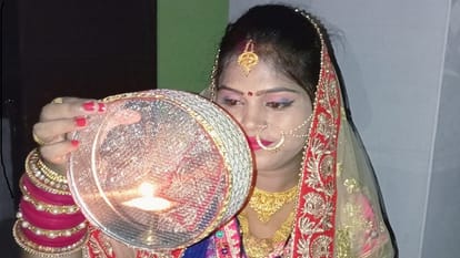 करवा चौथ पर चांद को अर्घ्य देती महिला