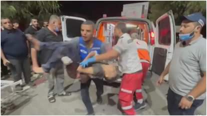 स्कूल पर हमले के बाद घायलों को अस्पताल ले जाते।