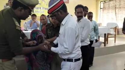 महिला से पेट्रोल की बोतल छिनती पुलिस।