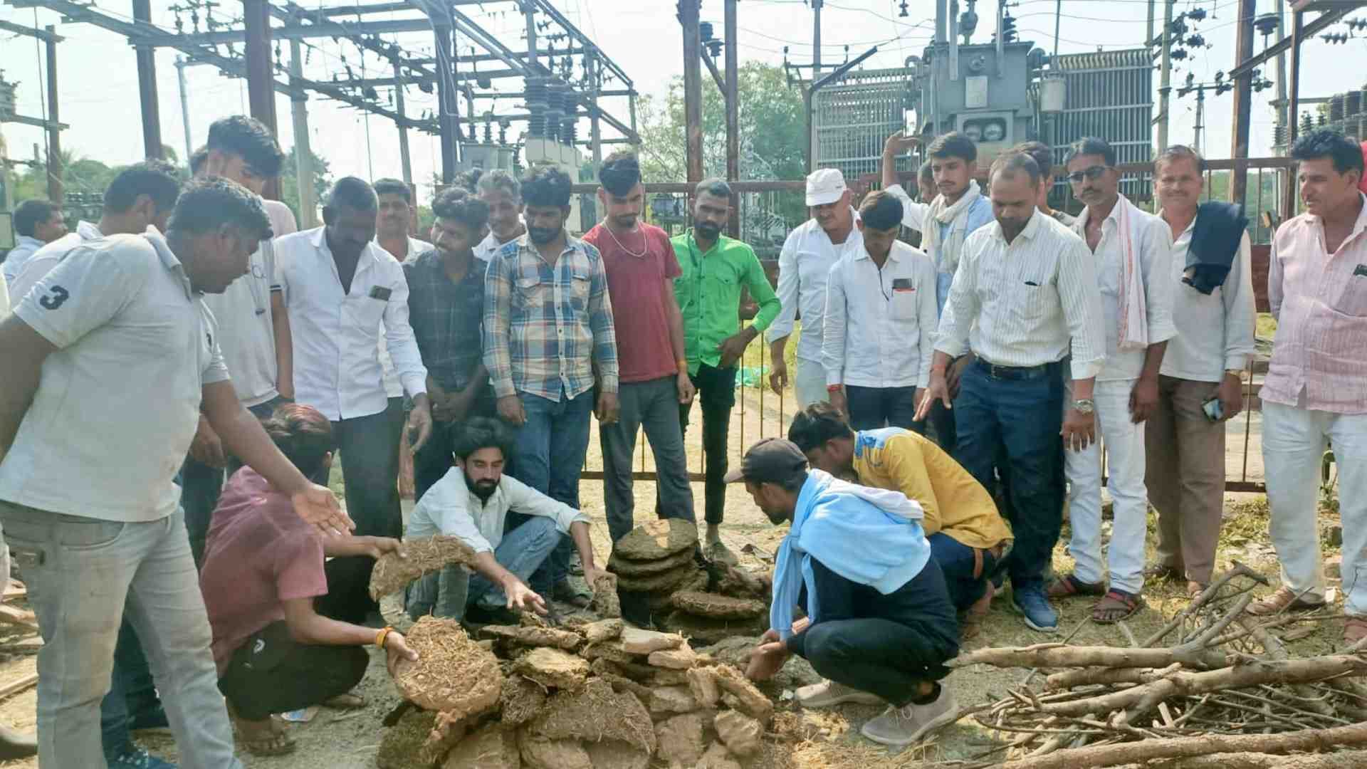 बिजली ग्रिड के बाहर धरने पर बैठे ग्रामीण।