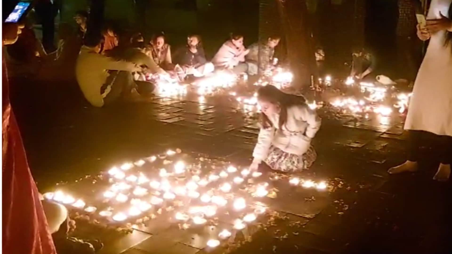 मंदिर में दीपदान करते लोग