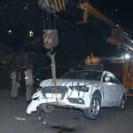 बन्नादेवी क्षेत्र में जीटी रोड पर क्षतिग्रस्त कार को हटाती जेसीबी