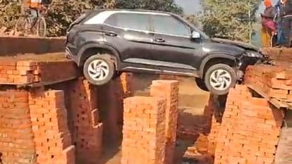 Car hanging in the air between bridge under construction in Shahjahanpur