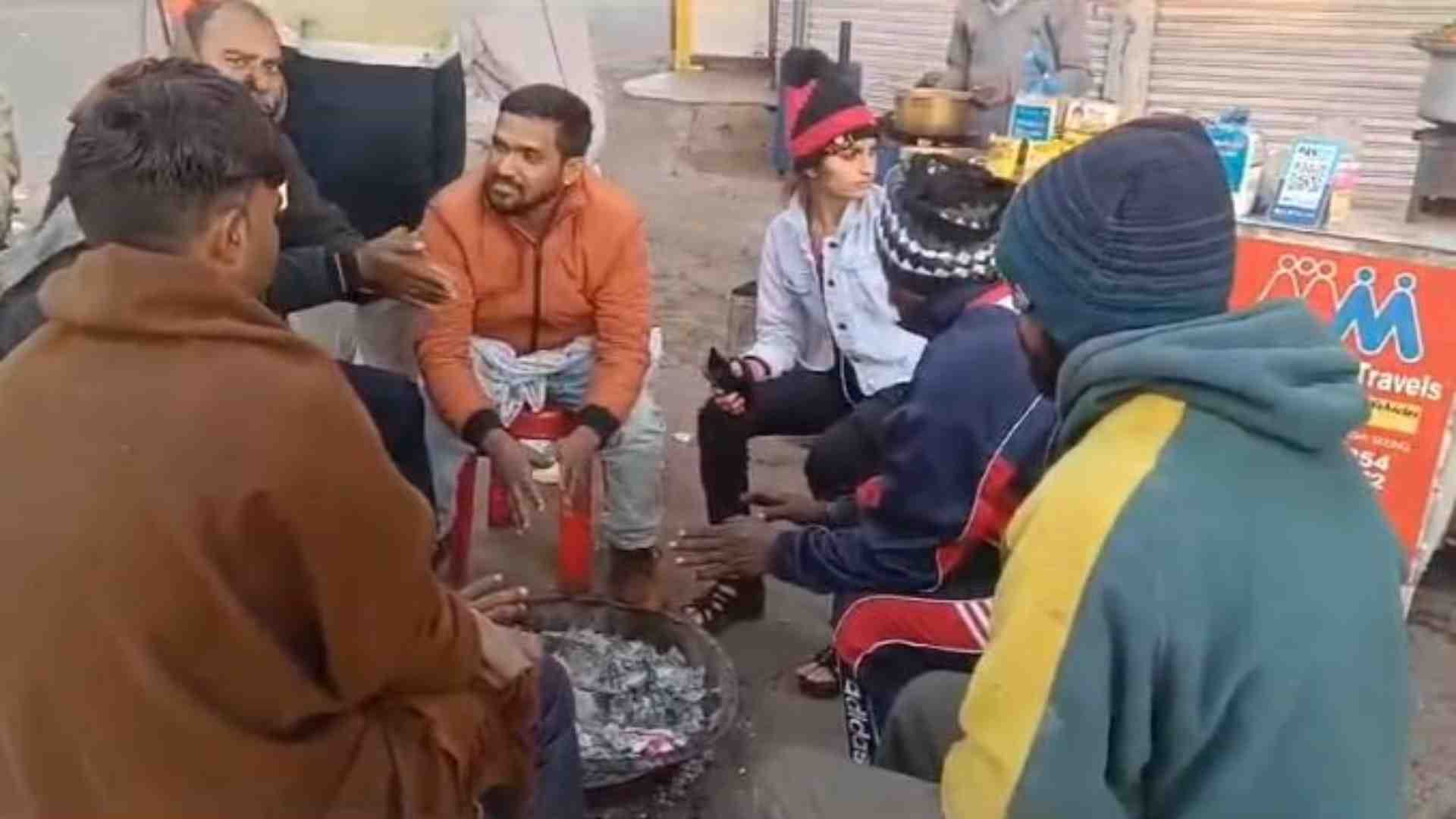 ठंड में हाथ तापते स्थानीय लोग।