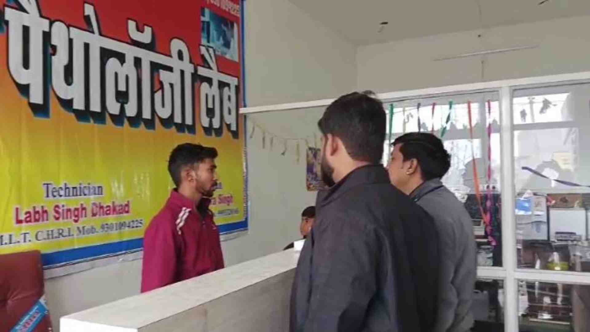 लैब में पूछताछ करते टीम के सदस्य।