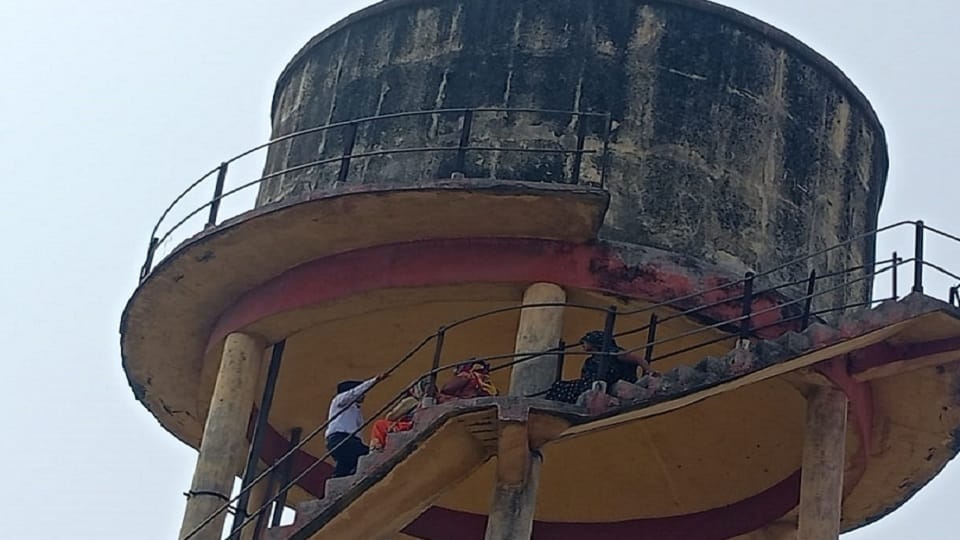 Women climb on water tank to solve waterlogging problem