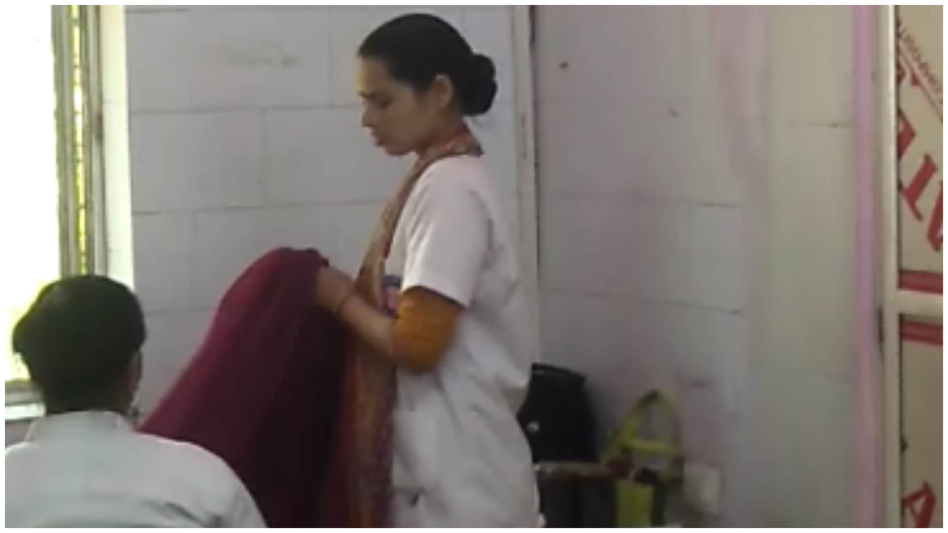 साड़ियां देख रही महिला स्टाफ।