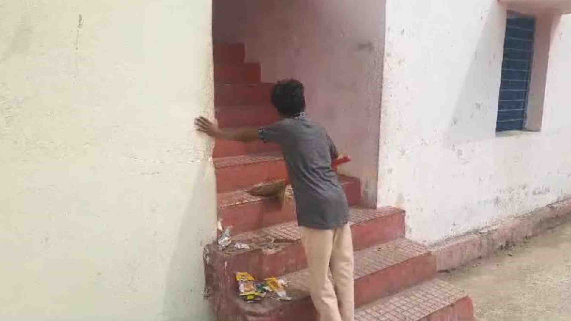 सीढ़ियों की सफाई करता बच्चा।