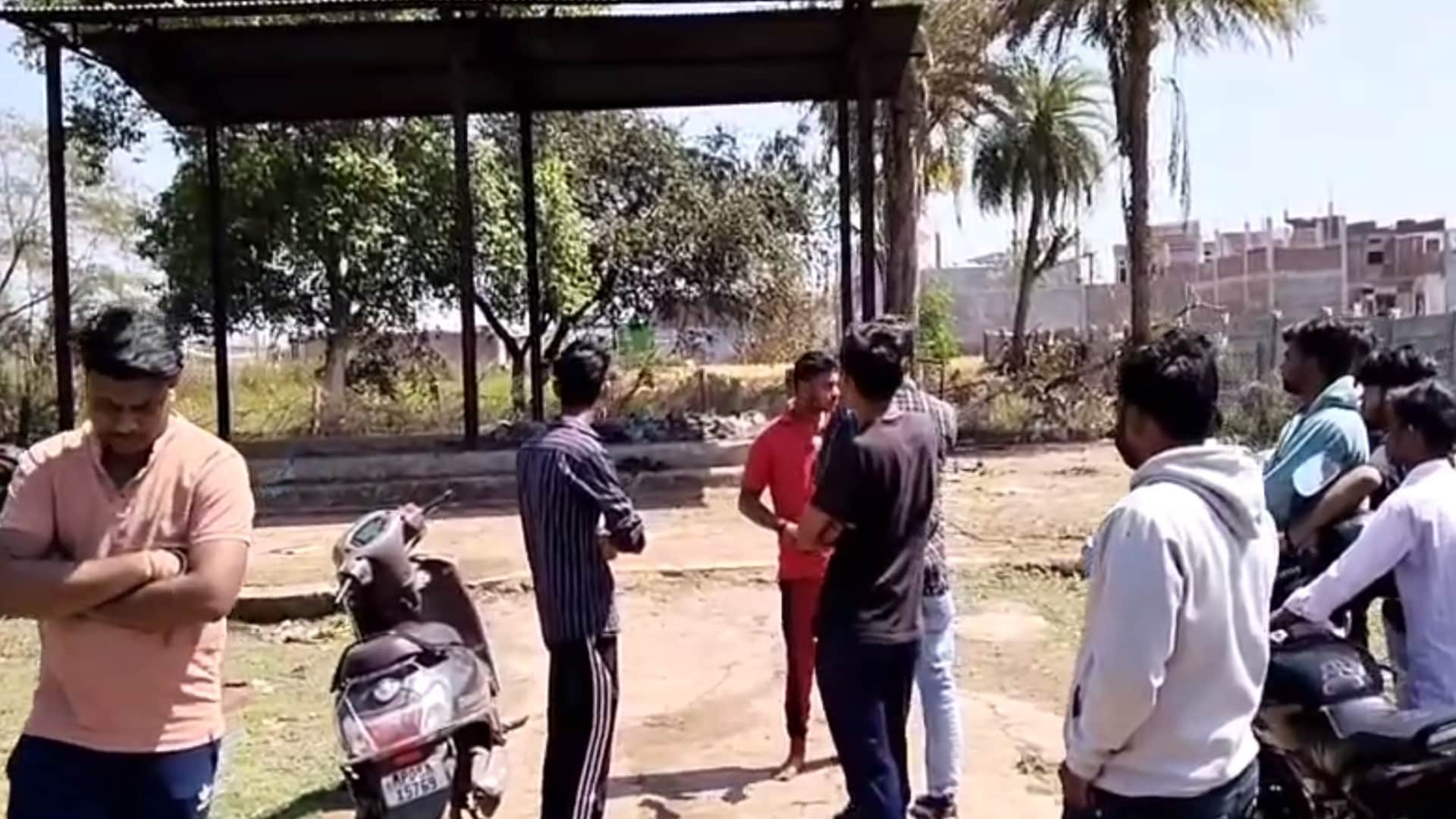 गुना में जलती चिता से राख उठाते दो लोगों को परिजनों ने पकड़ा।