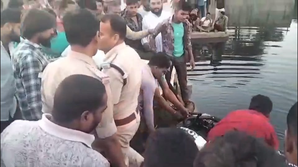 नदी से शव को बाहर निकालते पुलिस और स्थानीय लोग