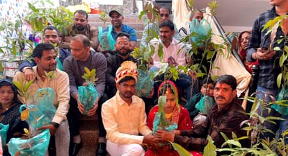 विदाई के समय उपहार में मिले पौधे लिए वर वधू व बाराती