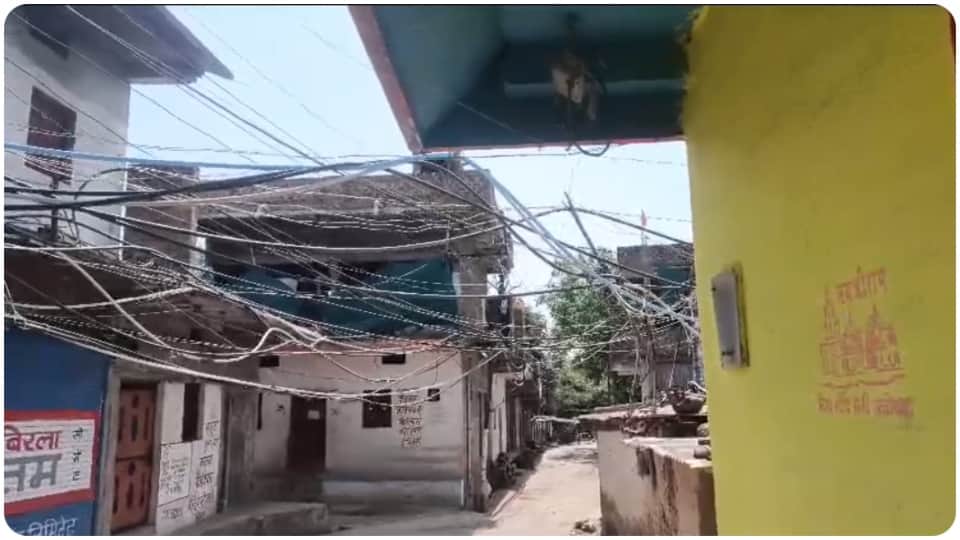गली के ऊपर से गुजर रहे पानी के पाइप।
