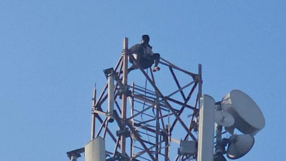 Young man climbs mobile tower under the influence of alcohol
