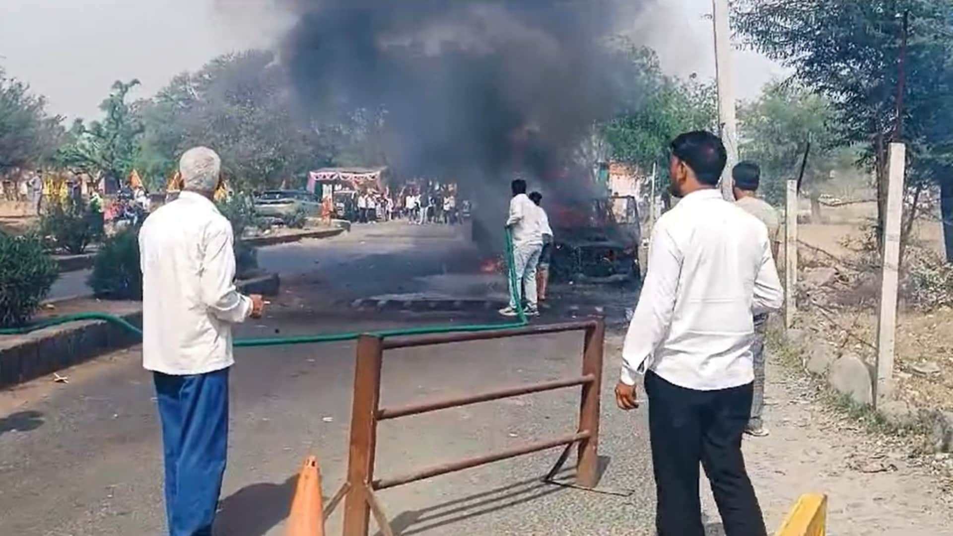 सड़क पर जलती हुई स्कॉर्पियो गाड़ी