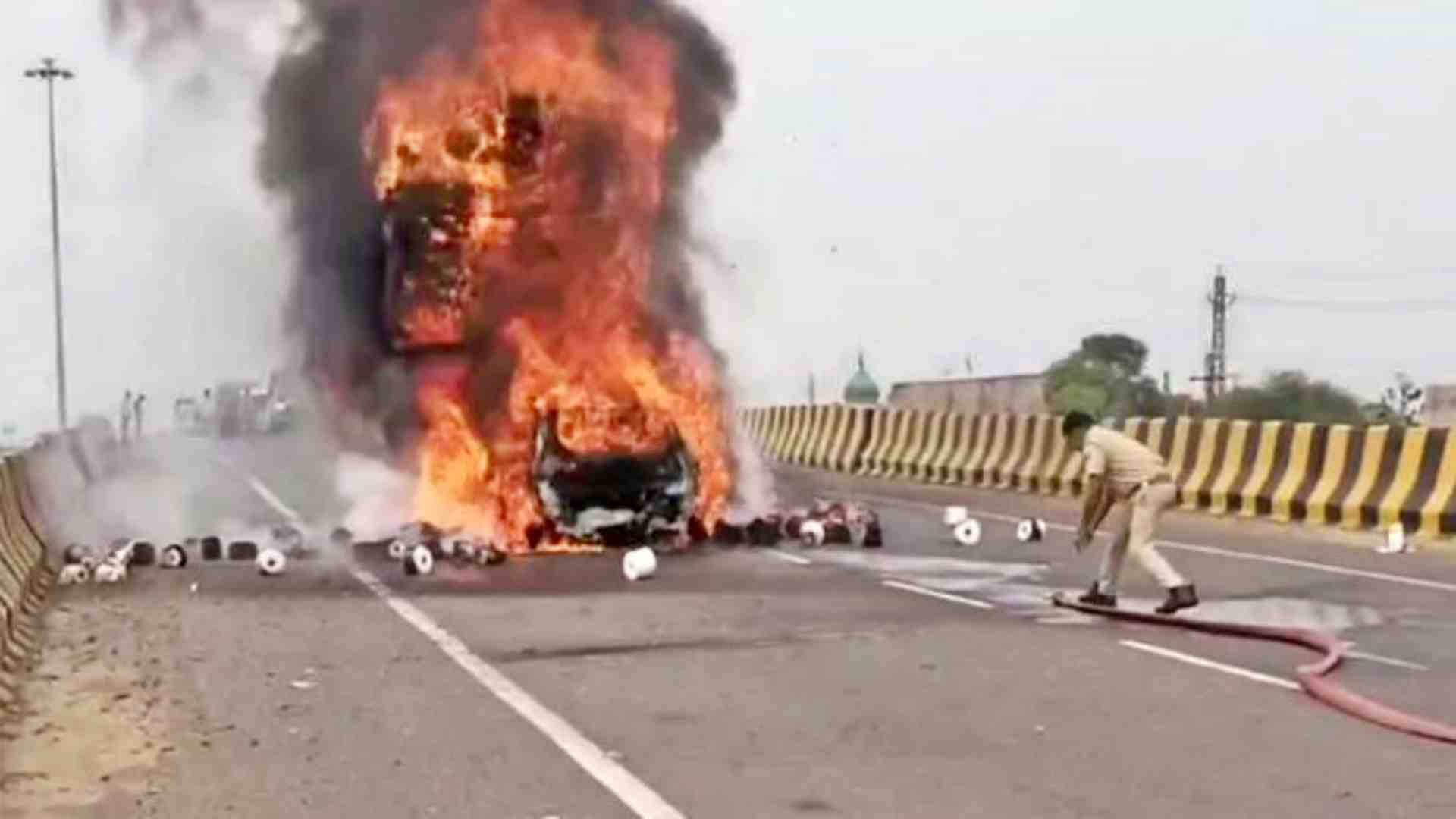 कार में लगी आग बुझाने का प्रयास करते फायरकर्मी।
