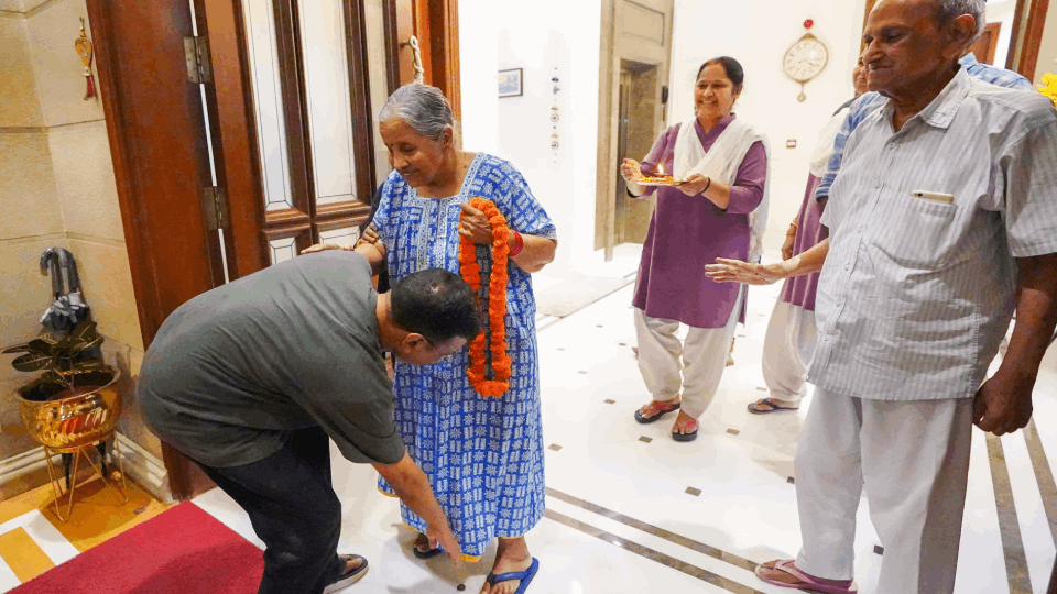 arvind kejriwal grand welcome at home fireworks touched mother feet  sanjay singh hugged photos