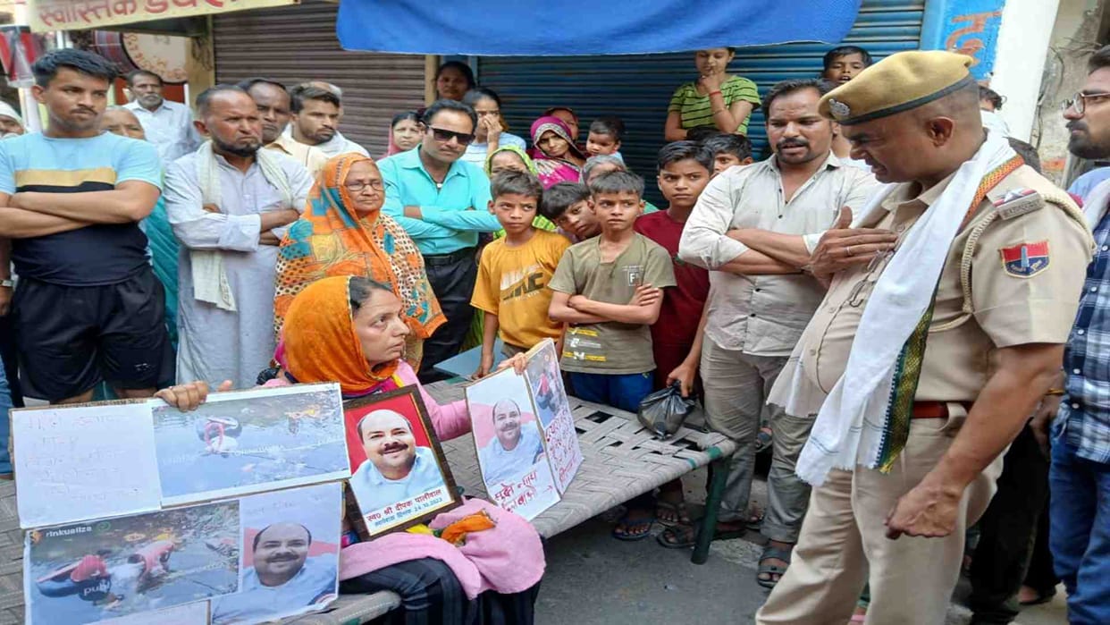 Bharatpur News: Woman sitting on dharna by placing a cot on the road in the afternoon