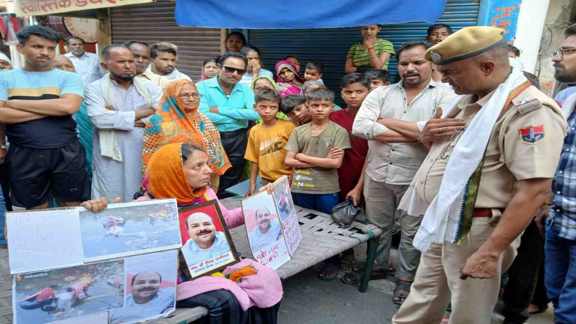 धरने पर बैठी महिला।