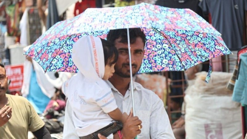 इंदौर में बच्चे को धूप से बचाते पिता। फोटो- जयेश मालवीय।