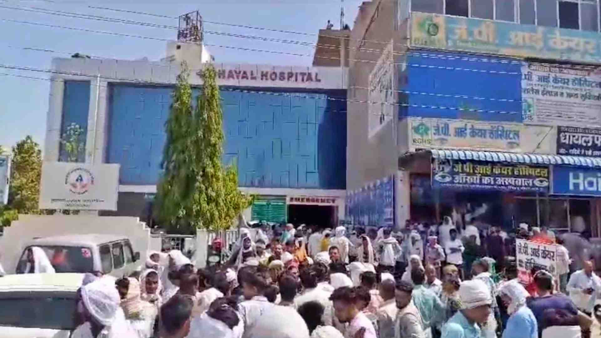 अस्पताल के बाहर प्रदर्शन करते लोग।