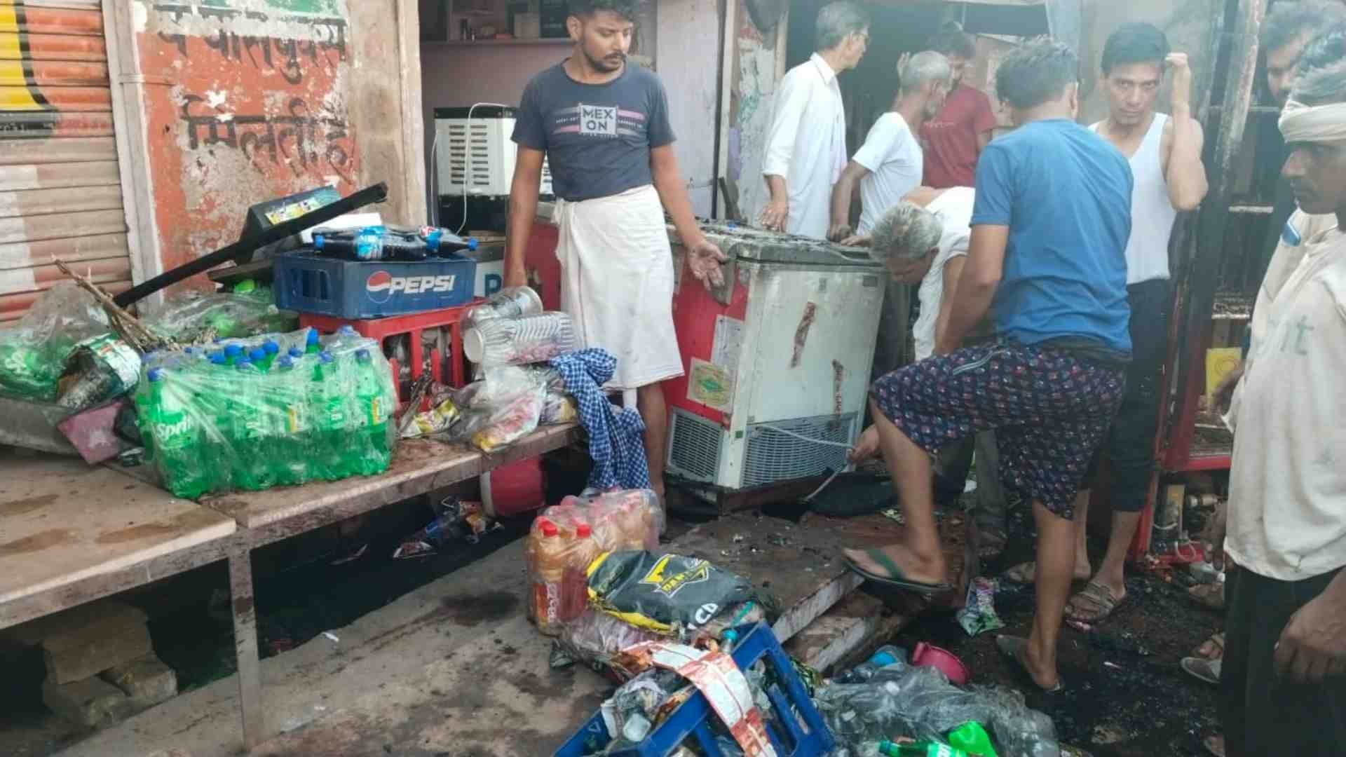 दुकान में जला सामान देखते स्थानीय लोग।