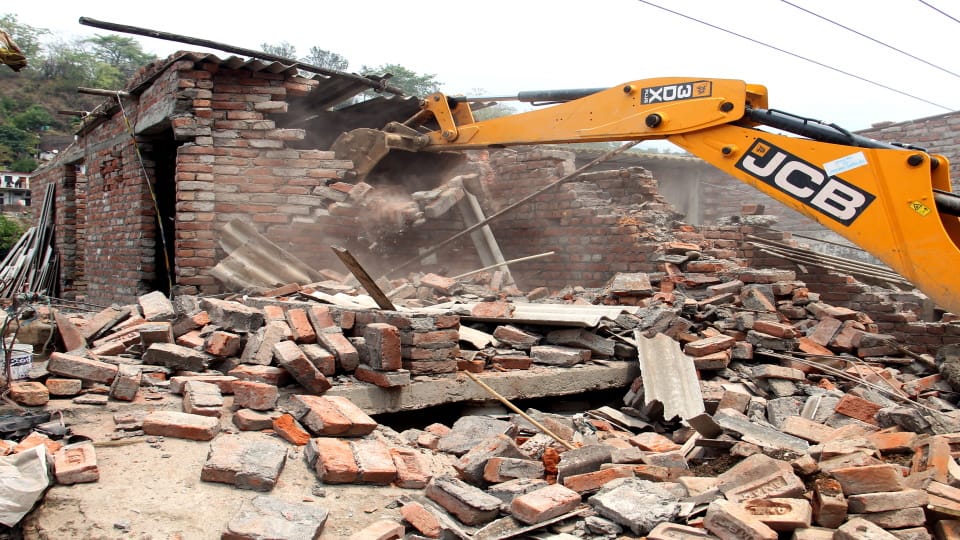 Dehradun encroachment bulldozer run in kathbangla slum colony Woman dies due to shock people block road