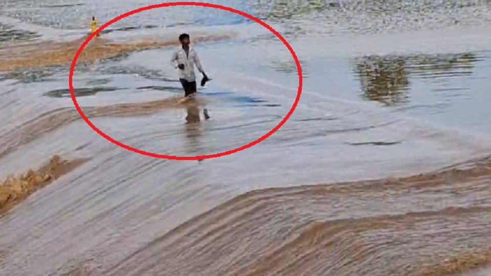 young man crossed anicut while watching his mobile phone in the middle of surging river in Balrampur Ramanujga