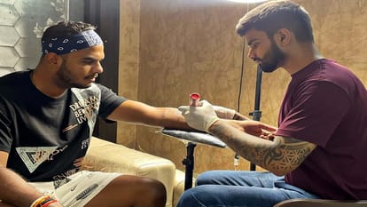 क्रिकेटर यश दयाल के हाथ पर टैटू बनाते रचित जादौन