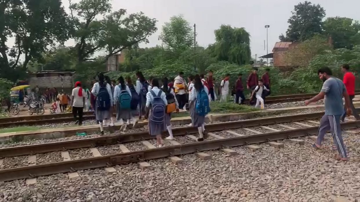 Prayagraj underpass filled with water, forced to cross railway track by risking life