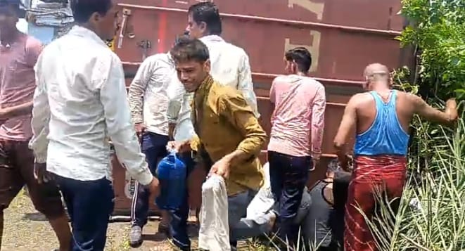 सागर में शराब कंटेनर पलटने के बाद शराब लूटते लोग
