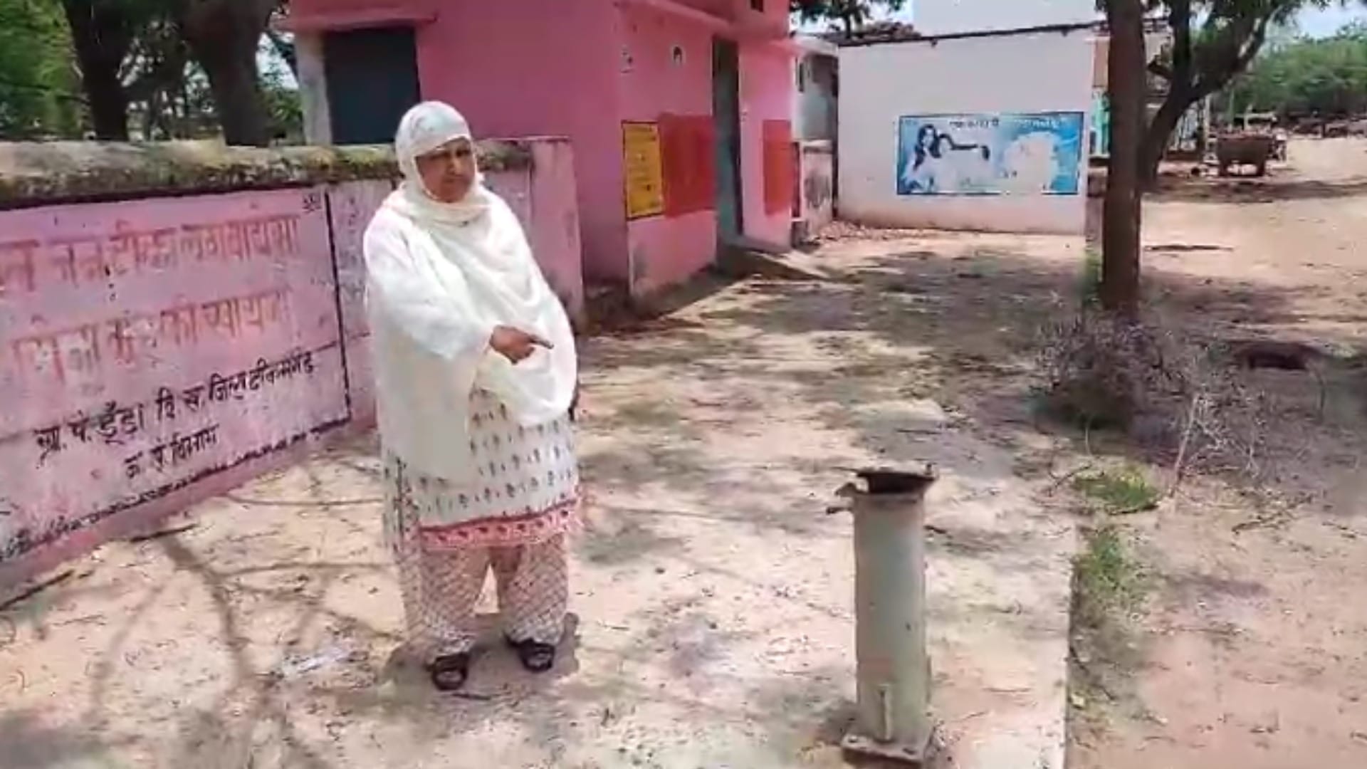 स्कूल में खराब पड़े बोर को दिखाती अध्यापिका