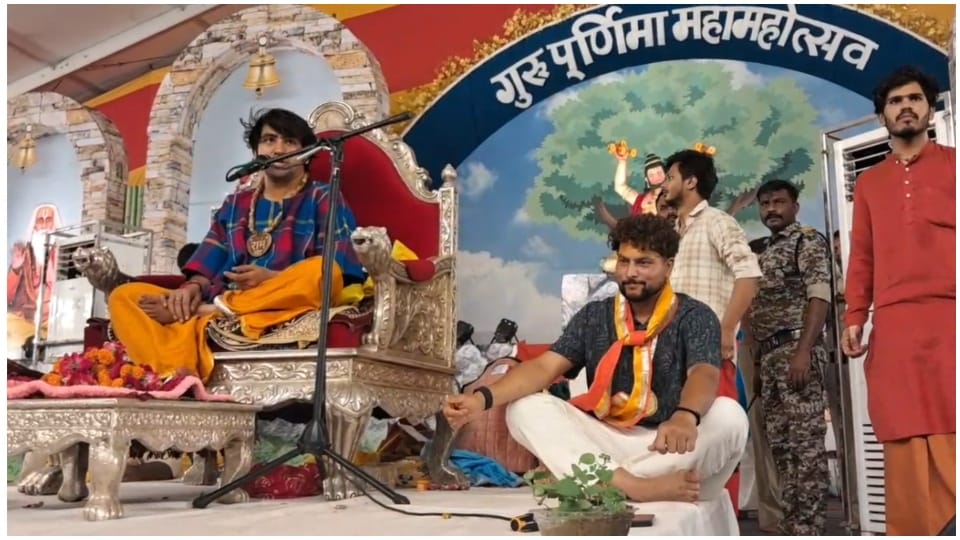 पंडित धीरेंद्र कृष्ण शास्त्री के साथ नीचे मंच पर बैठे कुलदीप यादव।