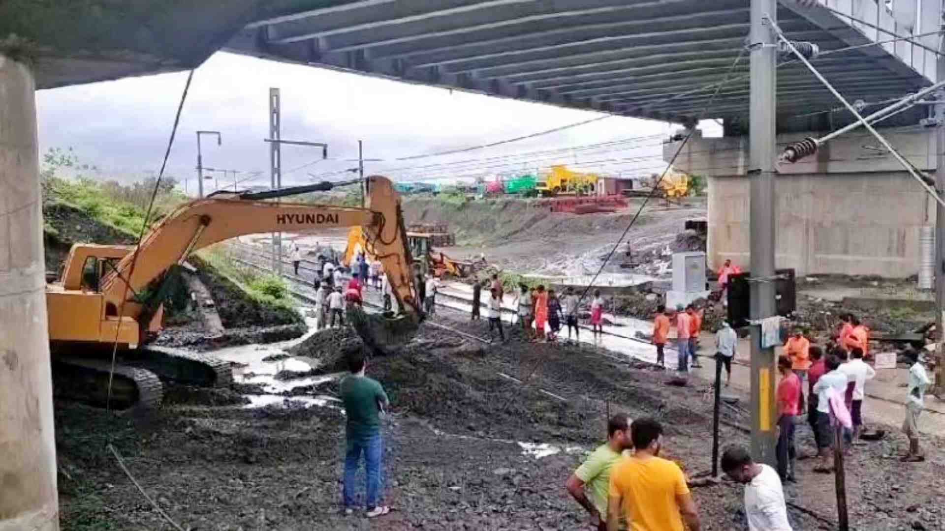 ट्रैक से मलबा हटाने में जुटे रेलवे कर्मचारी।