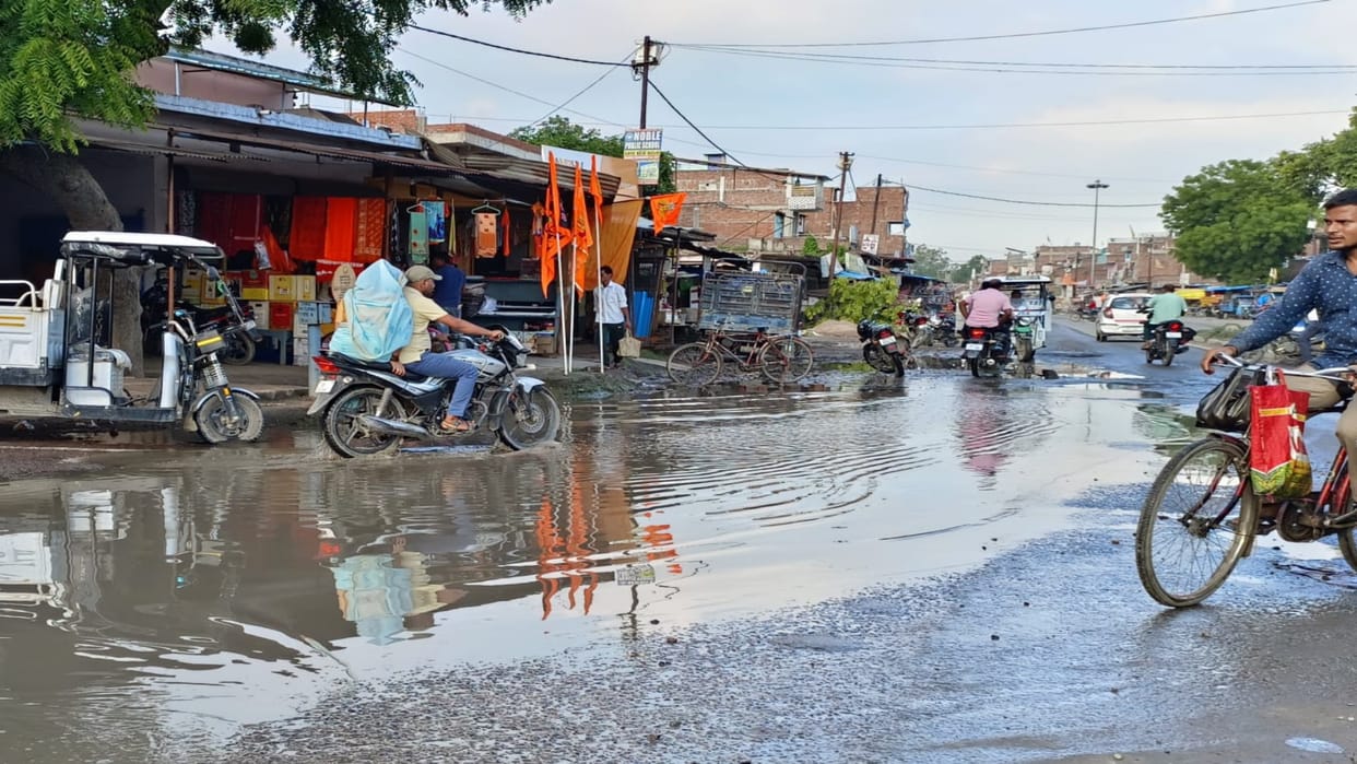 Water and mud filled in the potholes of the highway become a problem for the Kanwariyas