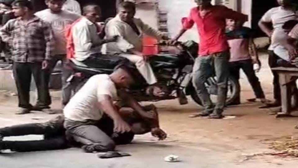 bully beat up young man with punches and kicks after knocking him down on road In Agra