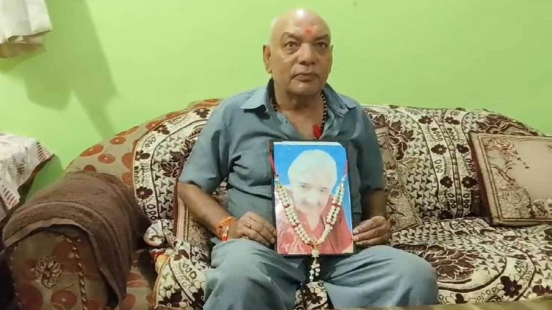 मां की तस्वीर लिए हुए बेटा