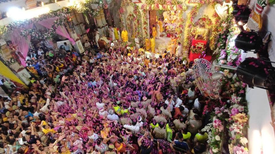 ठाकुर जी पर गुलाब की पंखुड़िया बरसाते श्रद्धालु