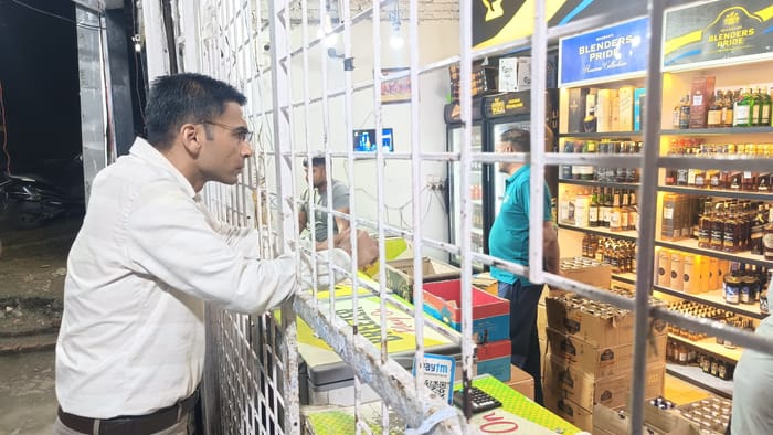 Dehradun DM Savin Bansal Raid on liquor shop as a customer shopkeeper gave bottle at over rating