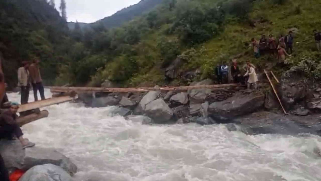 People crossing the overflowing Supin river with the help of a tree trunk Danger Uttarkashi Uttarakhand News