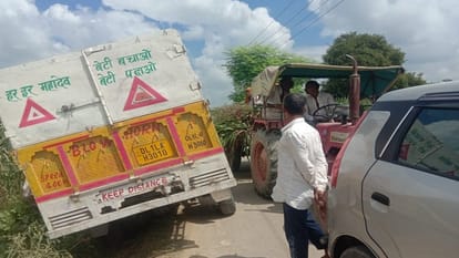 गांव का संकरा रास्ता और खेत की मेढ़ पर फंसा ट्रक।