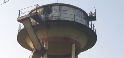 A cleaner climbed on a water tank in karnailganj in Gonda.
