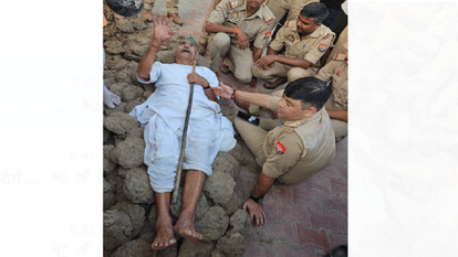 चिता पर लेटे किसान को उठाने की कोशिश करते थाना प्रभारी।