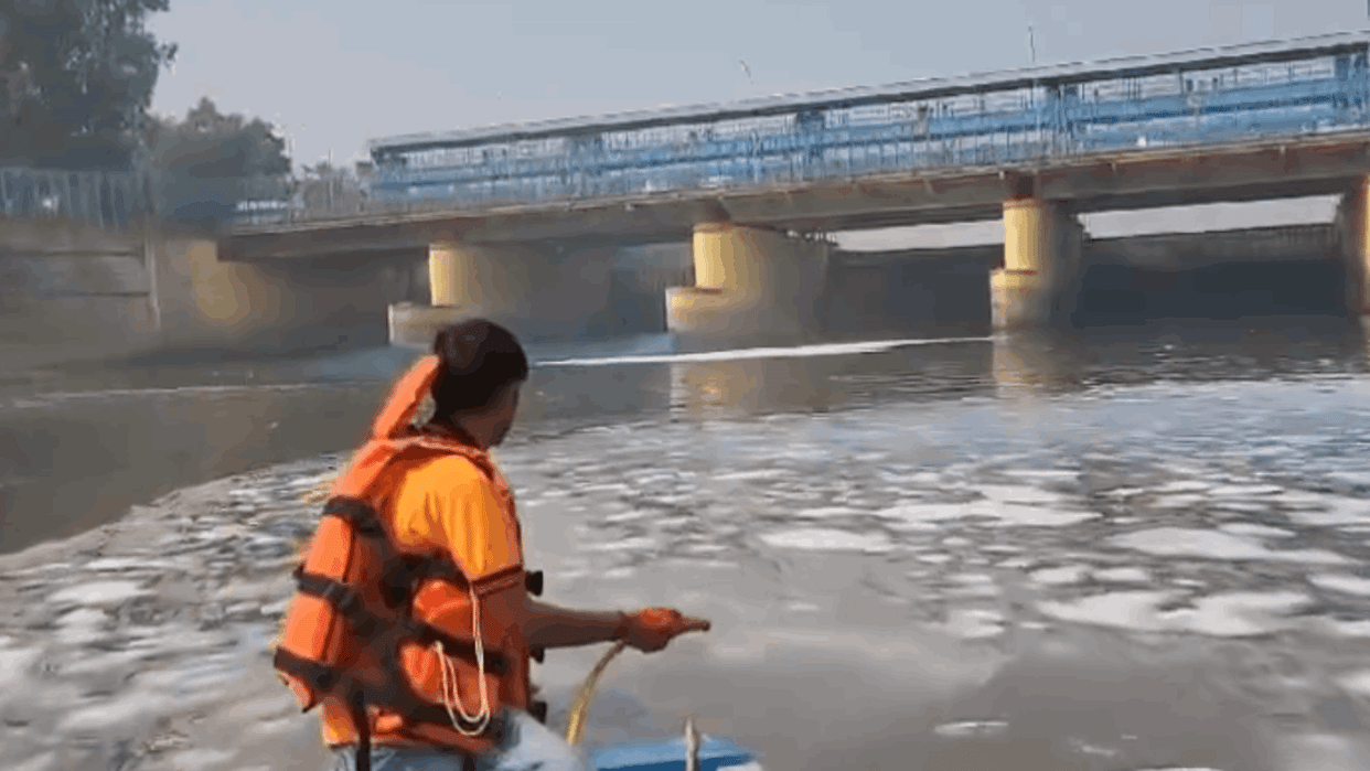 DJB team spraying chemicals to dissolve toxic foam in Yamuna river